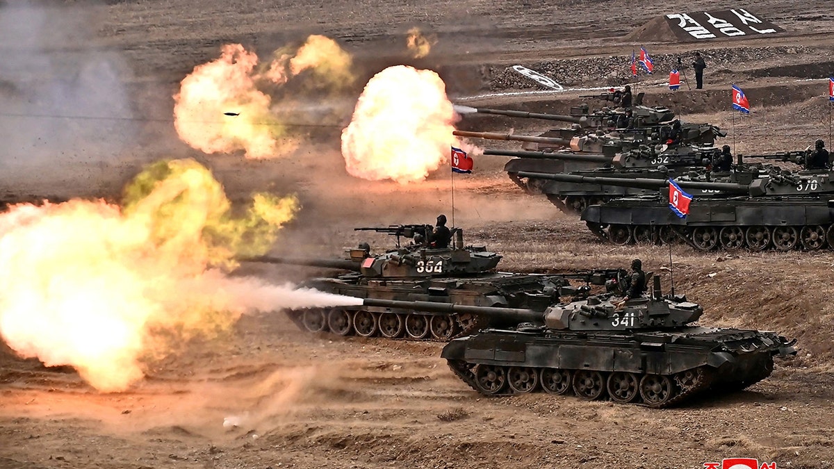 Several tanks firing weapons