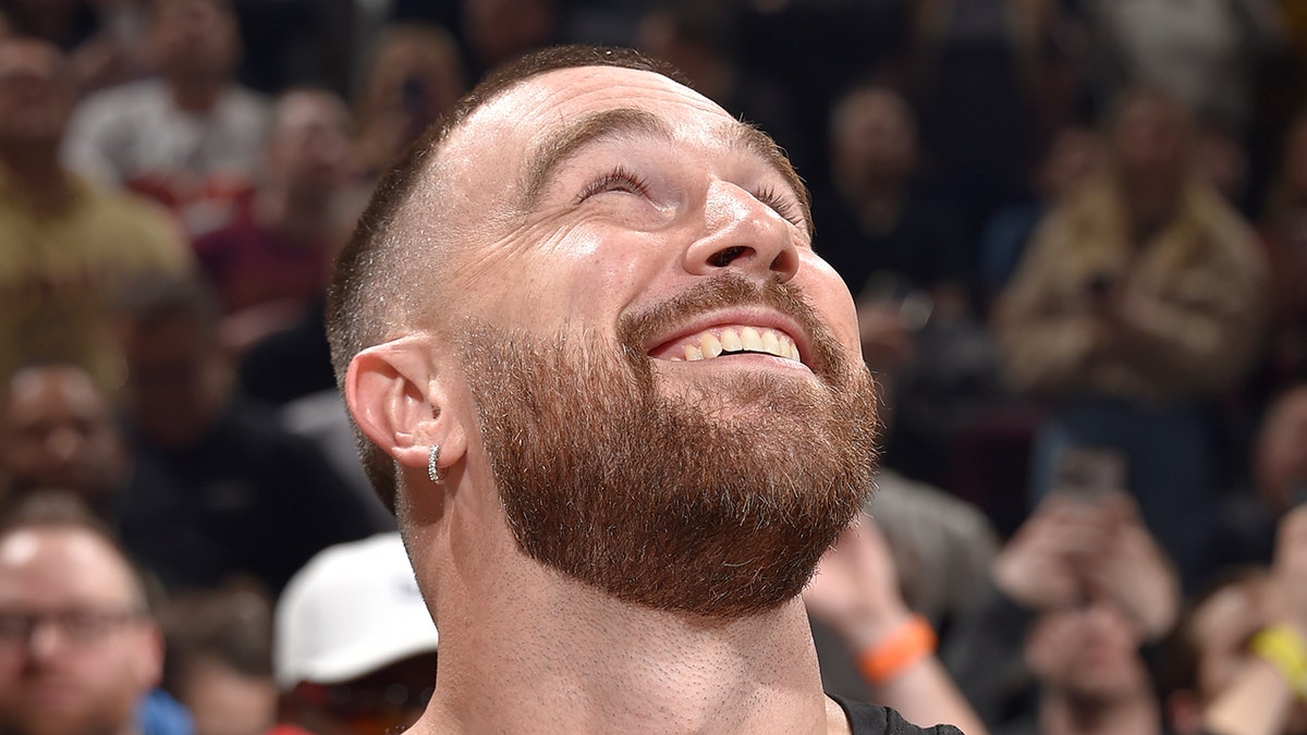 Travis Kelce looks up and smiles