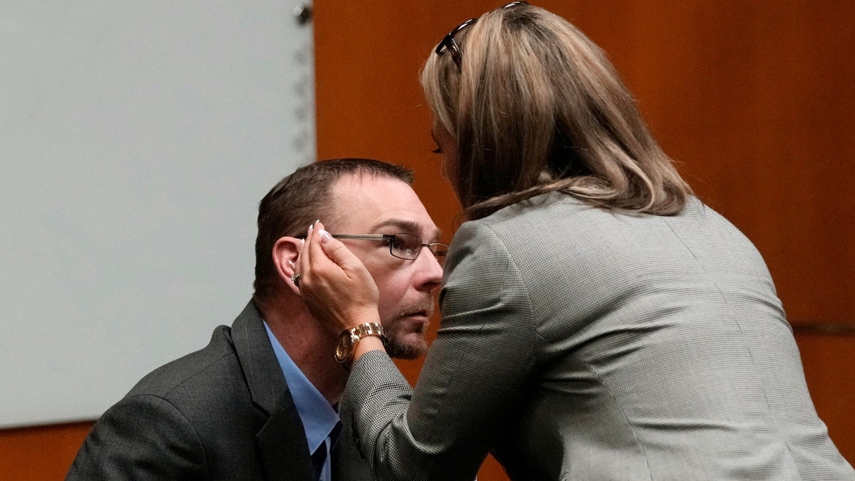 Defense attorney Mariell Lehman prepares to whisper in the ear of James Crumbley, Tuesday, March 12, 2024 in Pontiac, Mich.