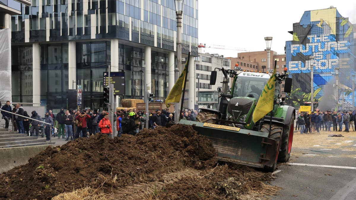 Tractor dumping manure near European council building in Brussels