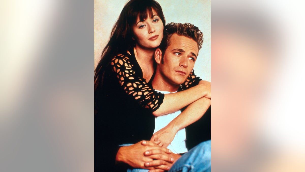 Luke Perry being embraced by Shannon Doherty