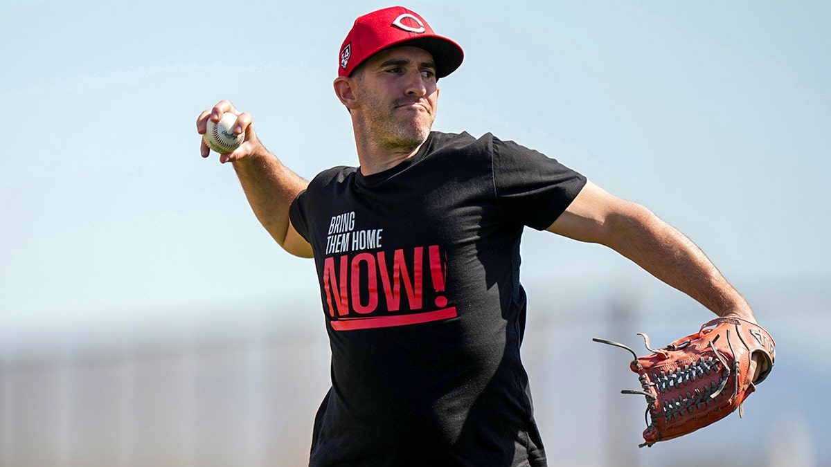 Alon Leichman throws with "Bring Them Home Now!" t-shirt on