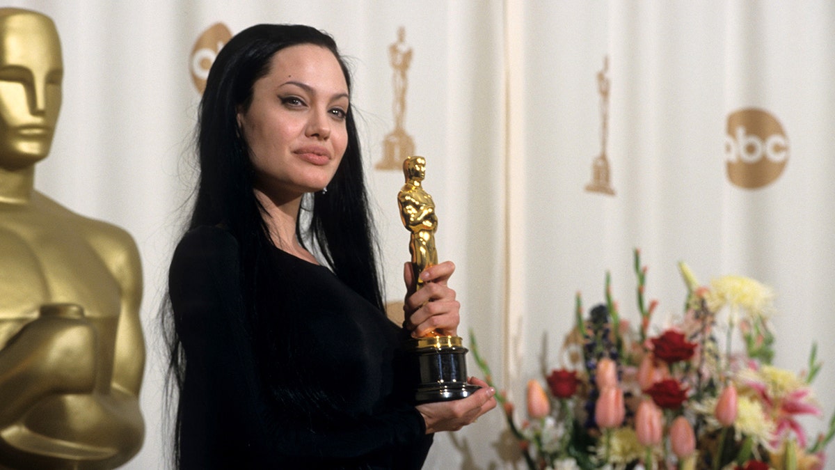 Angelina Jolie holding her Oscar in the press room