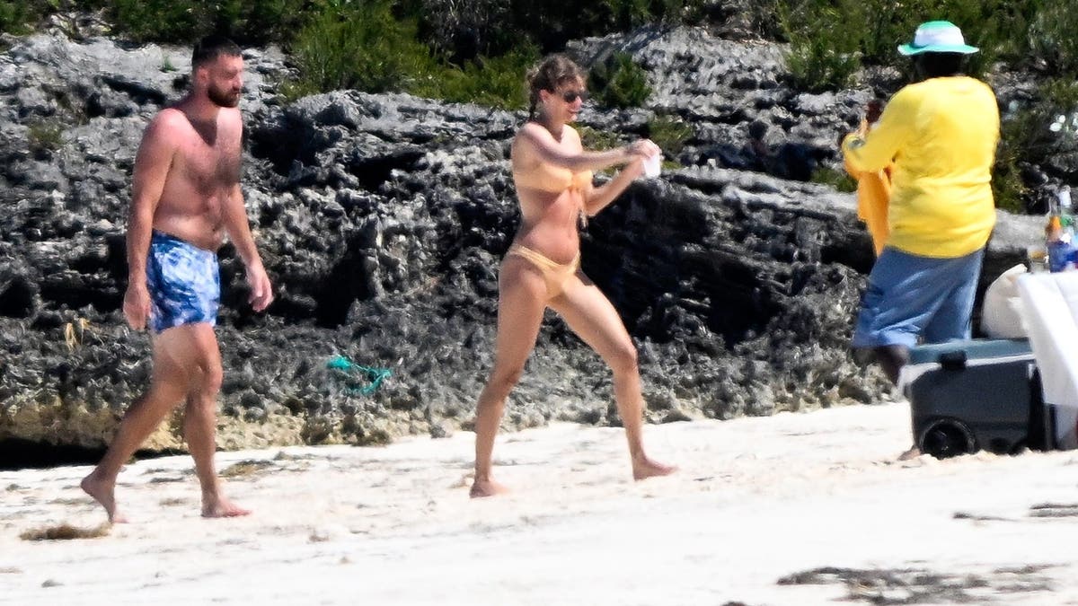 travis and taylor walking on the beach