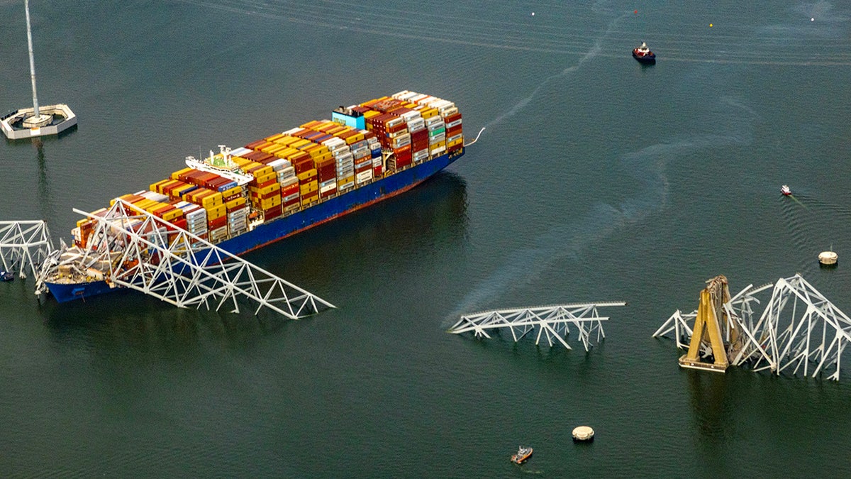 In an aerial view, the cargo ship Dali sits in the water after running into and collapsing the Francis Scott Key Bridge