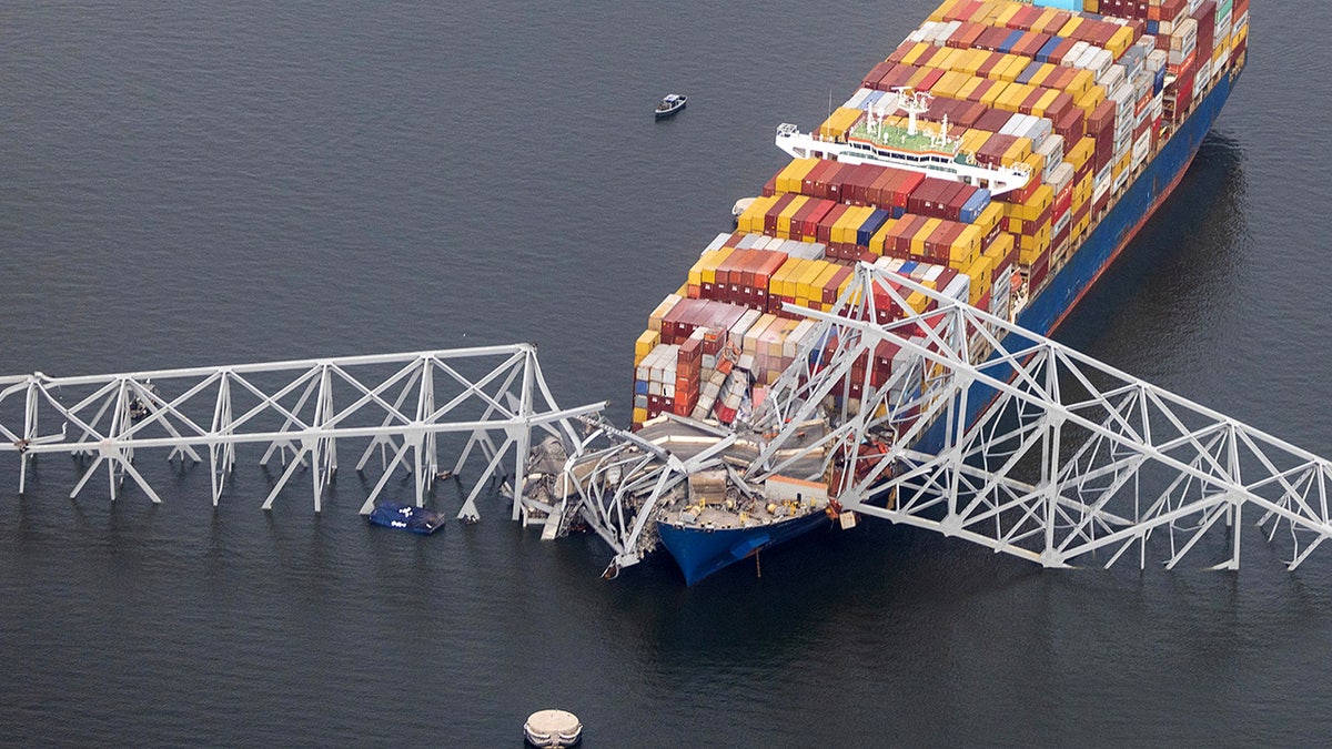 The cargo vessel  Dali sits successful  the h2o  aft  moving  into and collapsing the Francis Scott Key Bridge