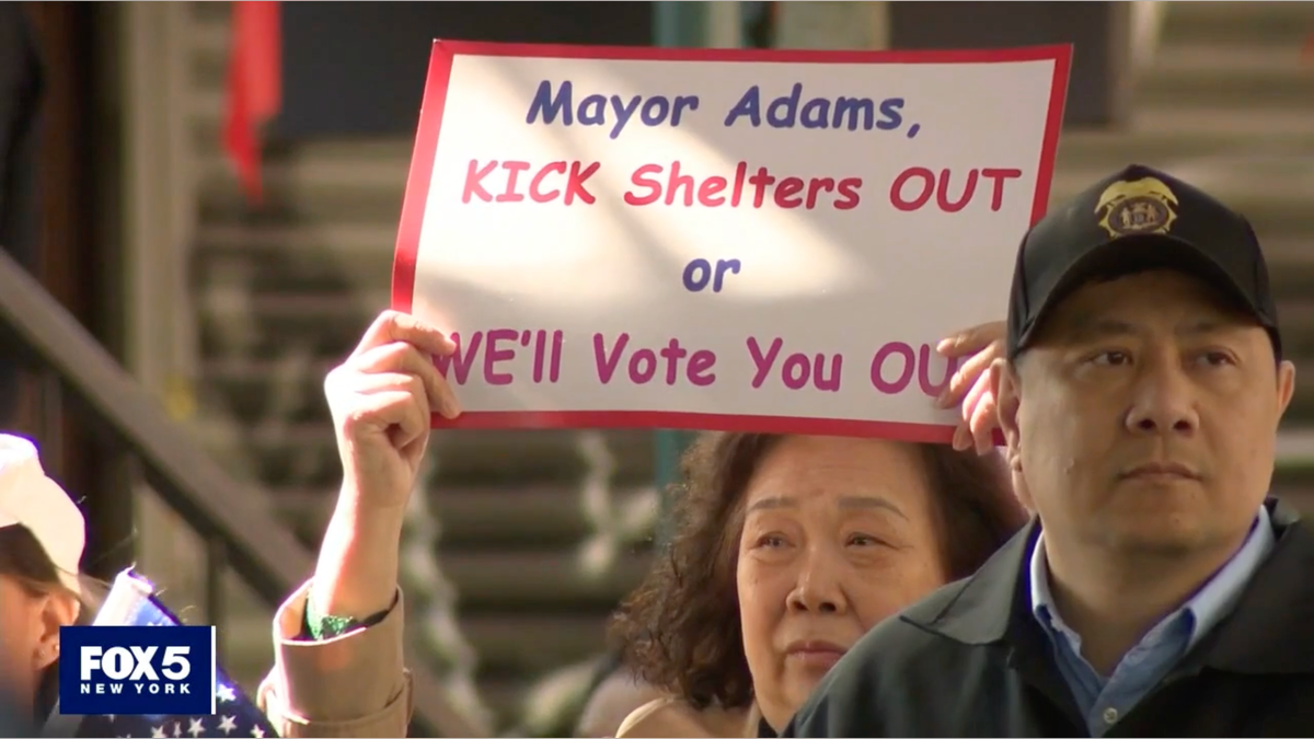 Sign saying 'Mayor Adams, kick shelters out or we'll vote you out'