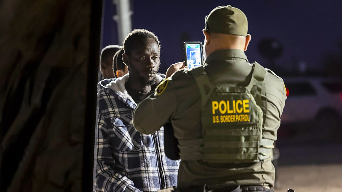 A Border Patrol processes an immigrant