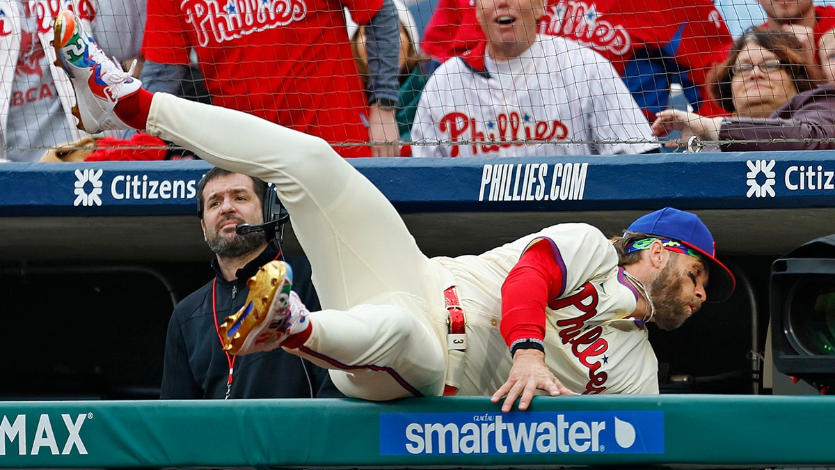 Bryce Harper flips over fence catching ball