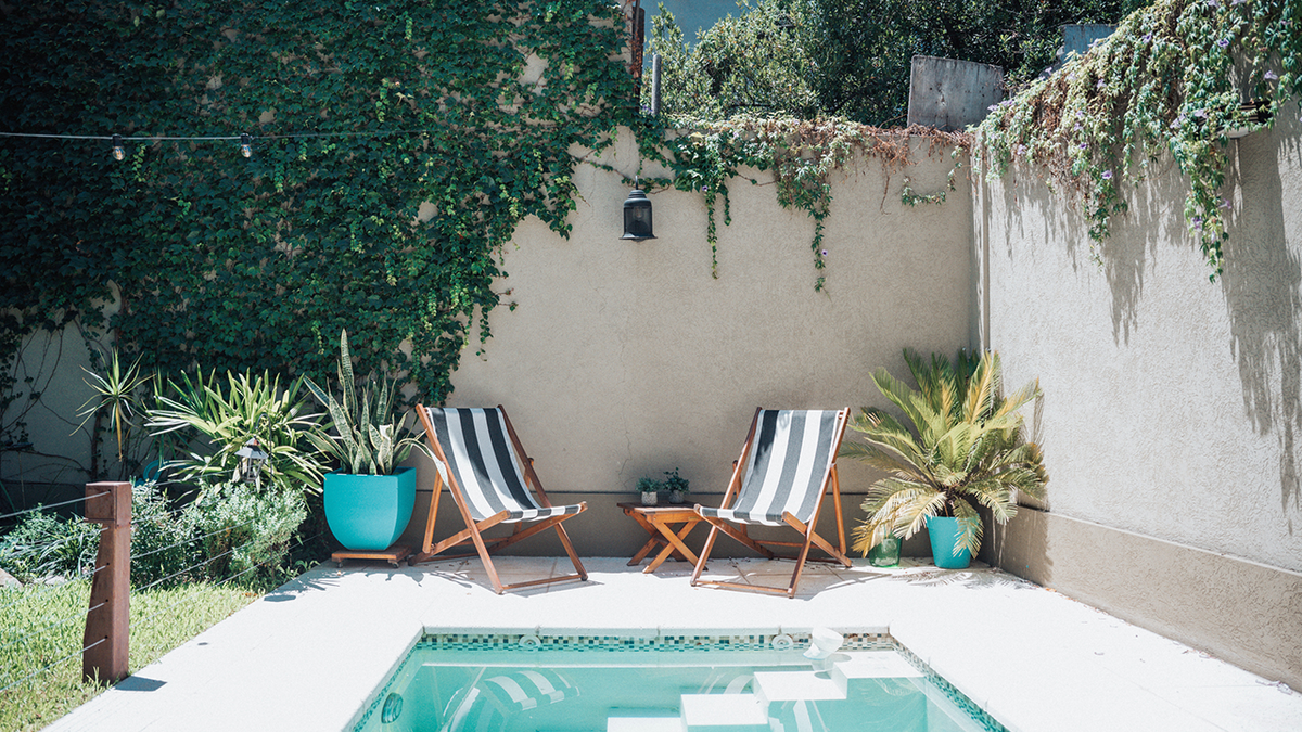Adding a statement statue and decorating a plain fence can add resort-style touches to your poolside transformation.