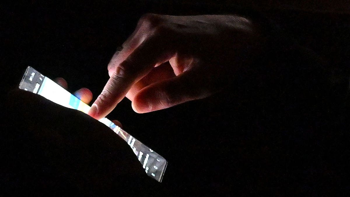 A man uses his smartphone in the dark