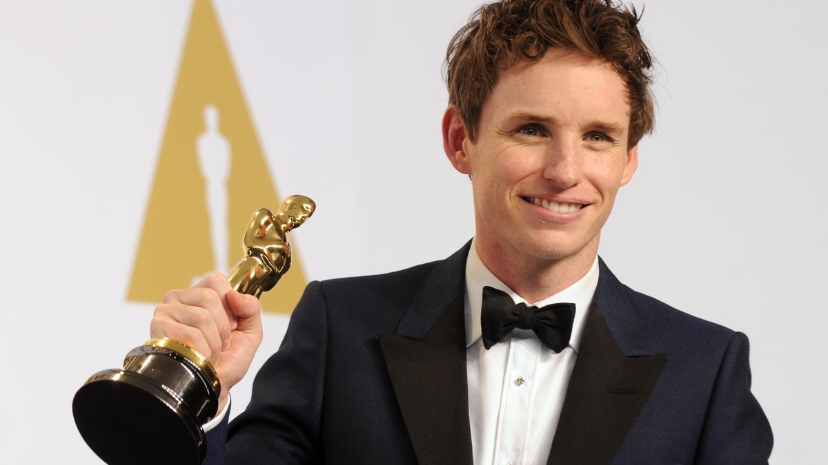 Eddie Redmayne holding Oscar statue