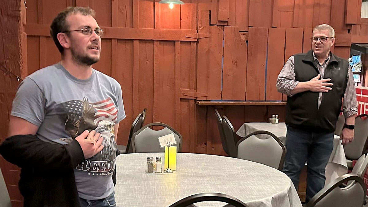 Congressional candidate Darren Bailey leads the Pledge of Allegiance at a campaign stop with the help of Casey resident Brandon Baston and his American flag T-shirt