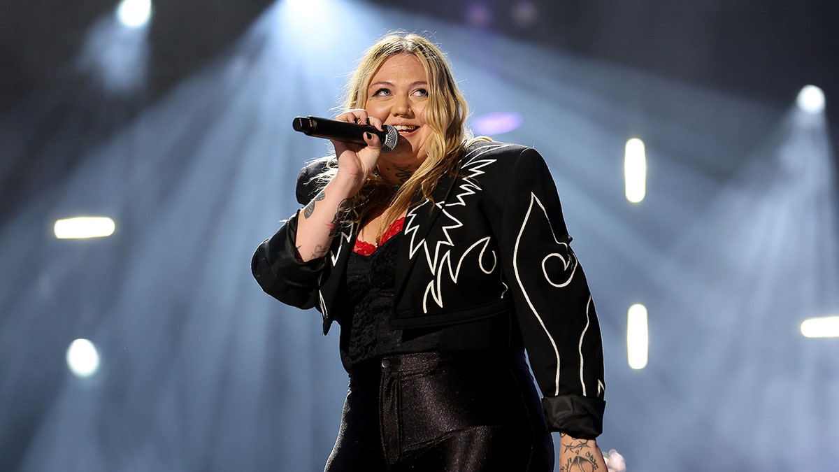 Elle King performing onstage with microphone