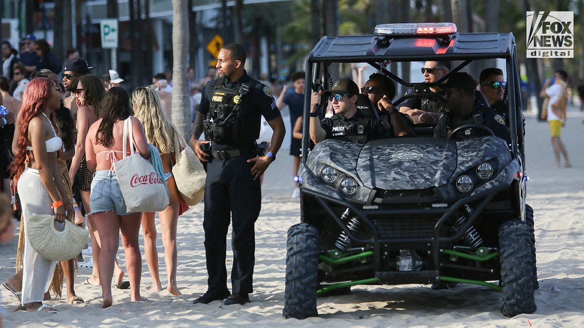 Fort Lauderdale police officers disperse Spring Breakers to prepare for a beach cleanup