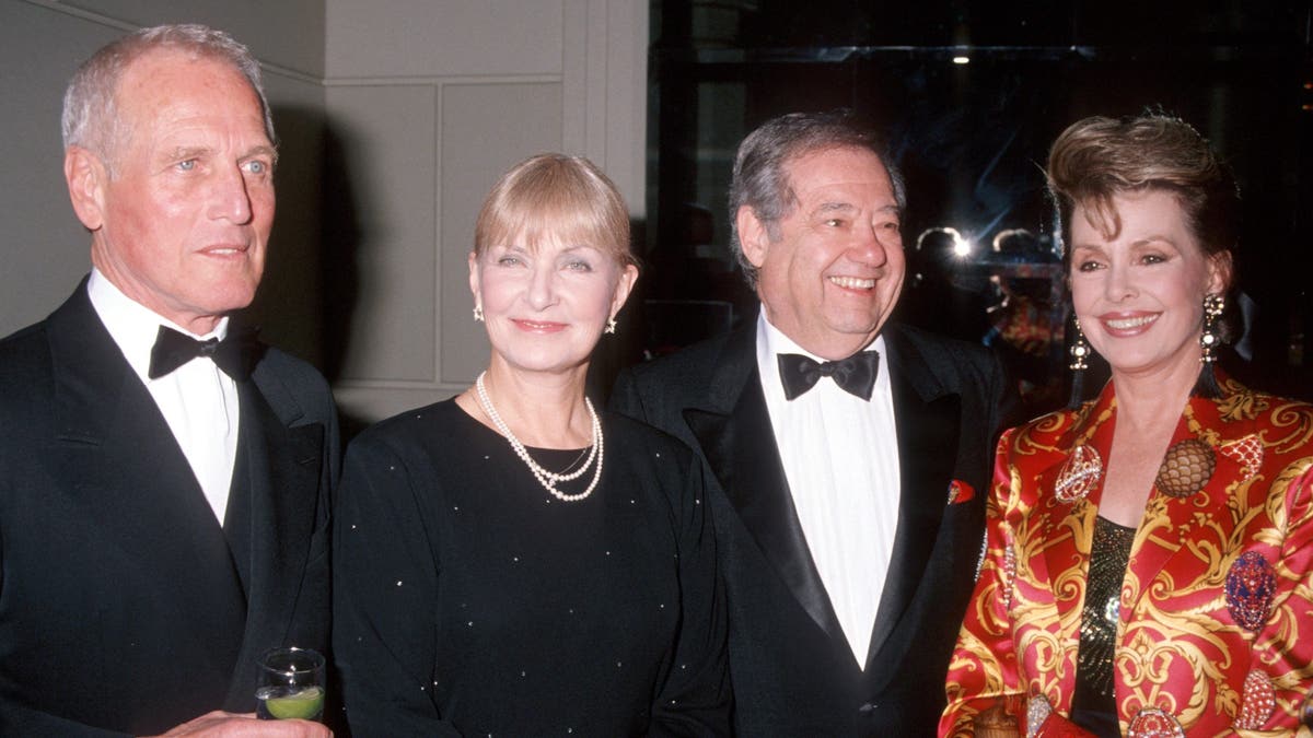 Paul Newman, Joanne Woodward, Warren Cowan e Barbara Rush sorrindo juntos para a câmera.