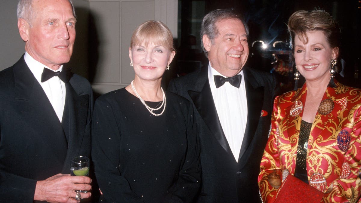 Paul Newman, Joanne Woodward, Warren Cowan and Barbara Rush smiling for the camera together.