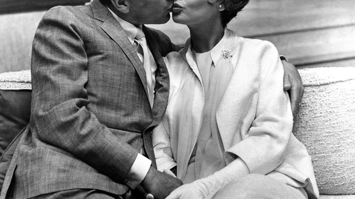 Frank Sinatra e Barbara Rush se beijando durante as filmagens de um filme.