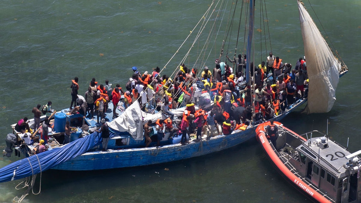 Guarda Costeira embarcando em veleiro cheio de migrantes