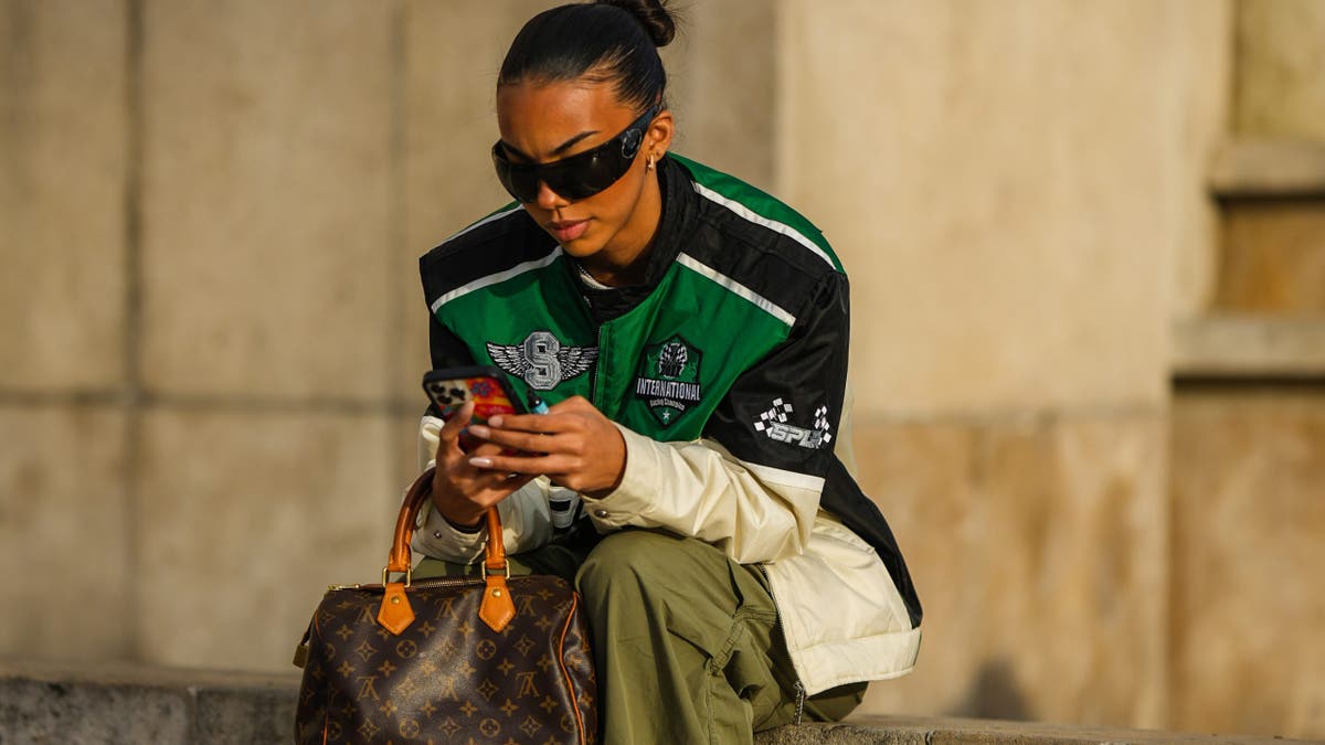 woman sitting typing on her iPhone