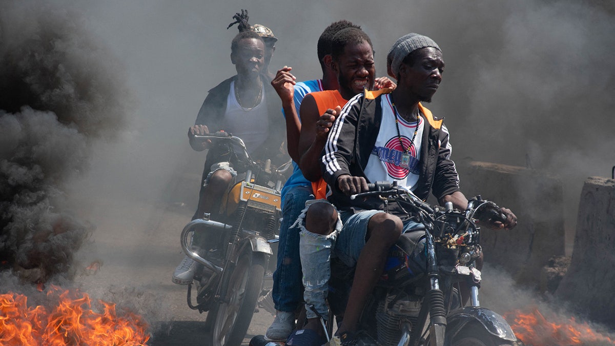 Haitian motorcyclists drive through fire