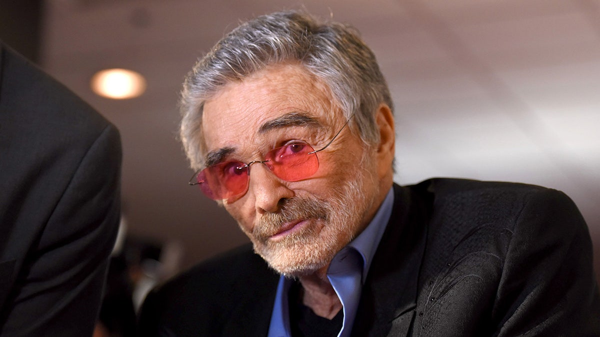 Burt Reynolds wearing red glasses