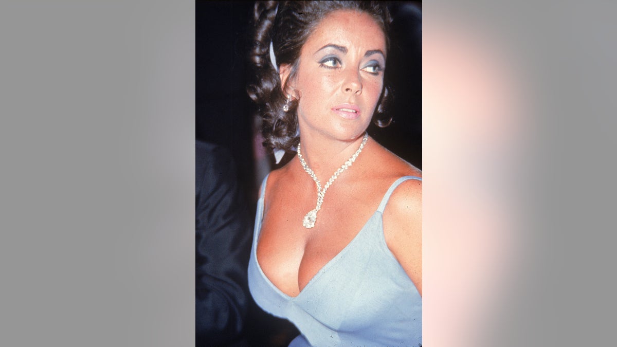 A close-up of Elizabeth Taylor wearing a low cut dress and diamonds