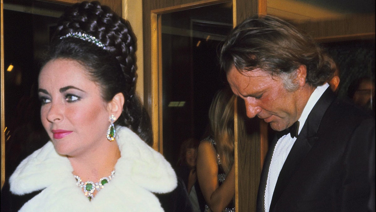 Elizabeth Taylor wearing emeralds and diamonds next to Richard Burton
