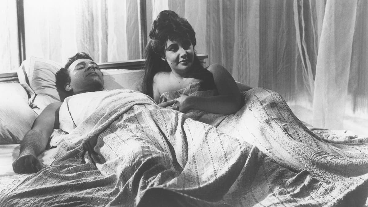 Elizabeth Taylor and Richard Burton laying in bed together