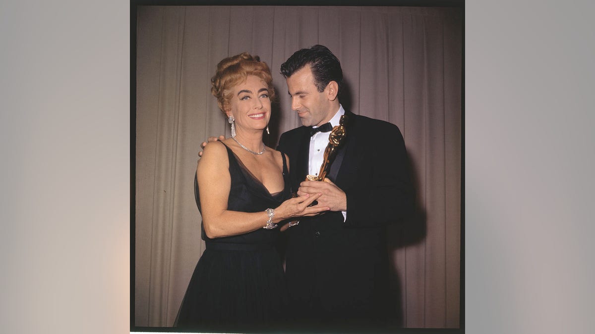 Joan Crawford holding an Oscar with a male star