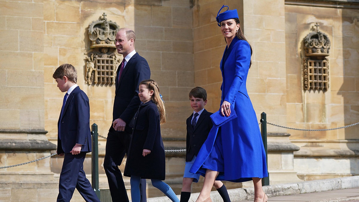 The Prince and Princess of Wales walking with their three children