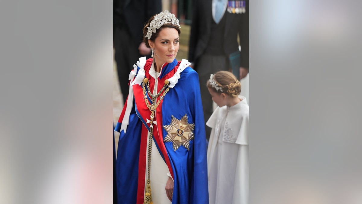 Kate Middleton looking serious in bright blue and red royal robes