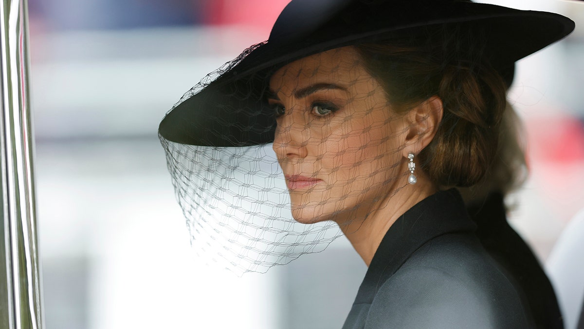 Kate Middleton looking to the side wearing all black