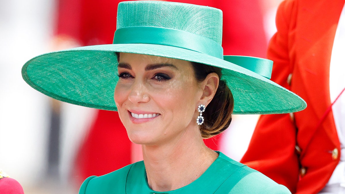 Kate Middleton wearing a large green hat and a matching outfit