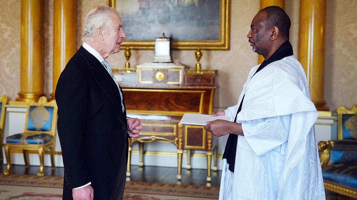 King Charles greeting a guest inside the palace