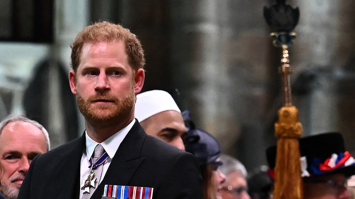 A close-up of Prince Harry in a suit with medals