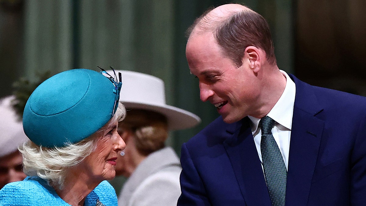 Queen Camilla and Prince William smile warmly at each other