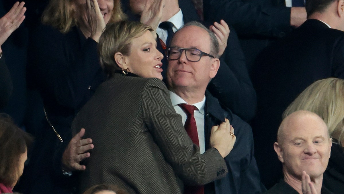 Prince Albert embracing Princess Charlene at a stadium