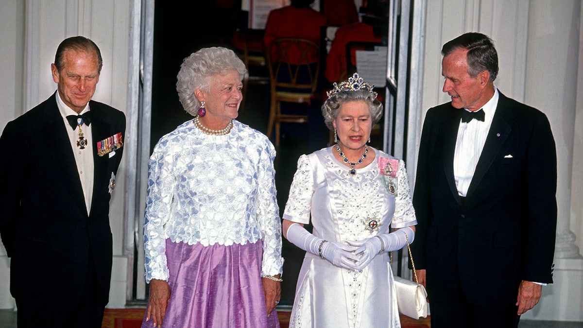 Queen Elizabeth and Prince Philip standing with the Bush family during a reception