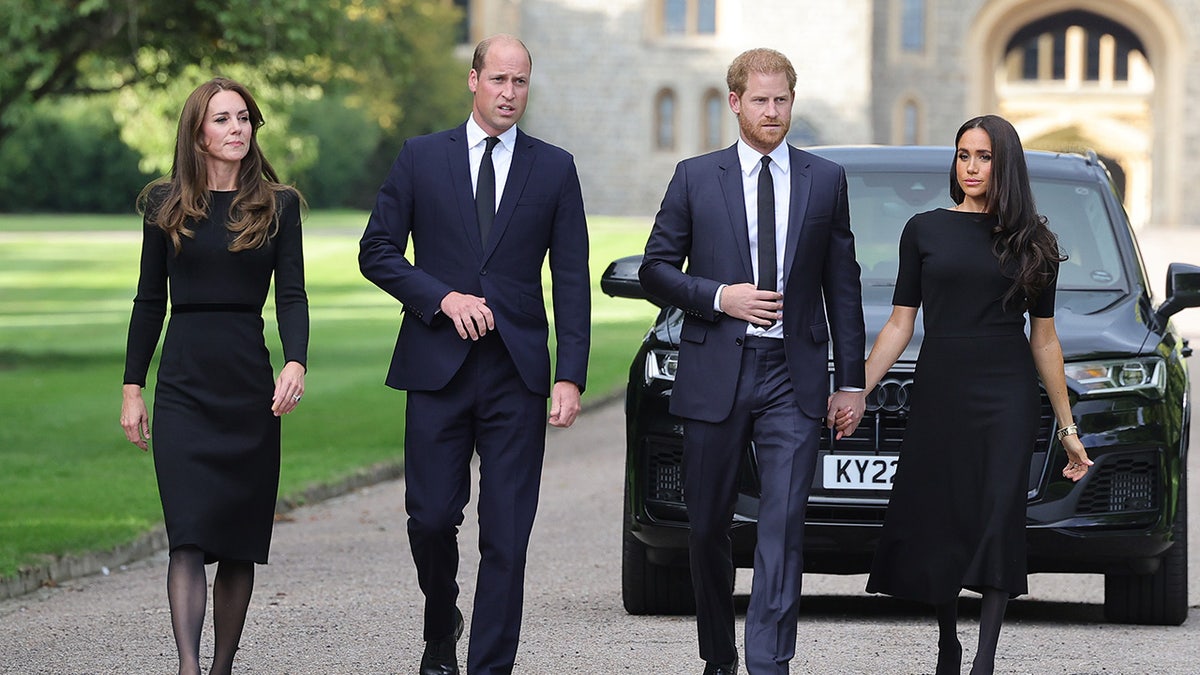 British royals walking together in front of a car looking somber