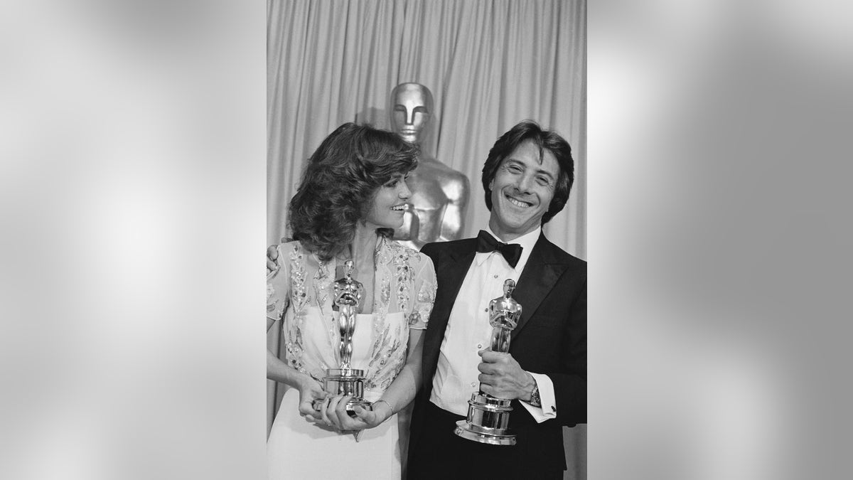 Sally Field smiling with Dustin Hoffman as they hold their Oscars