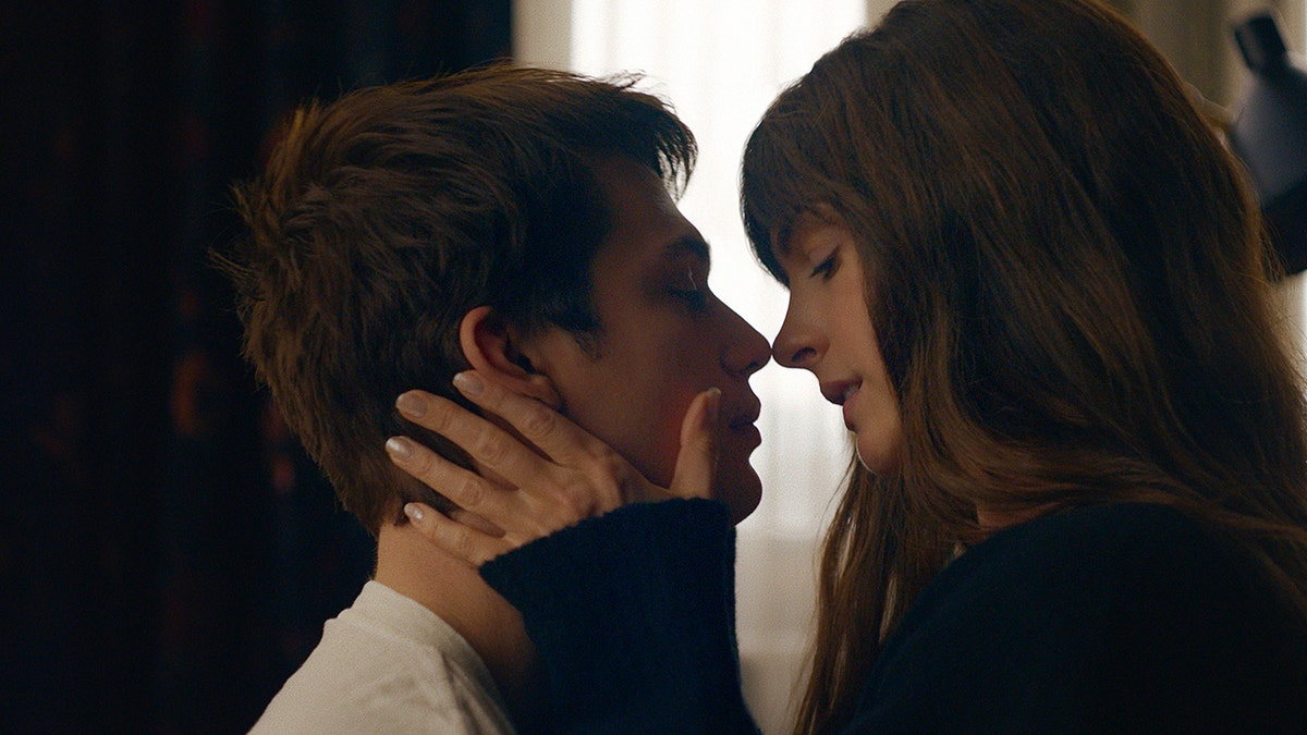 Anne Hathaway and Nick Galitzine almost kissing in a scene from The Idea of You