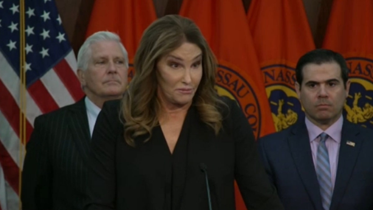 Caitlyn Jenner speaks behind a podium