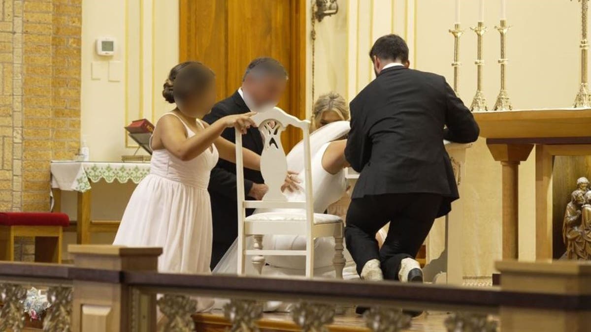 Wide image of bride crouched down at altar