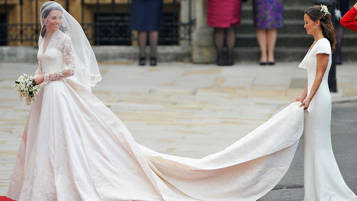 Pippa Middelton holds the train of Kate Middleton's wedding dress