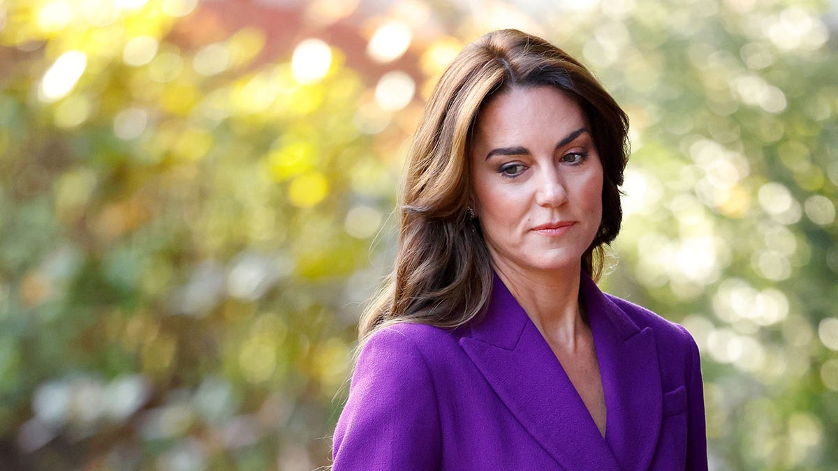 Kate Middleton wearing a purple suit and looking serious