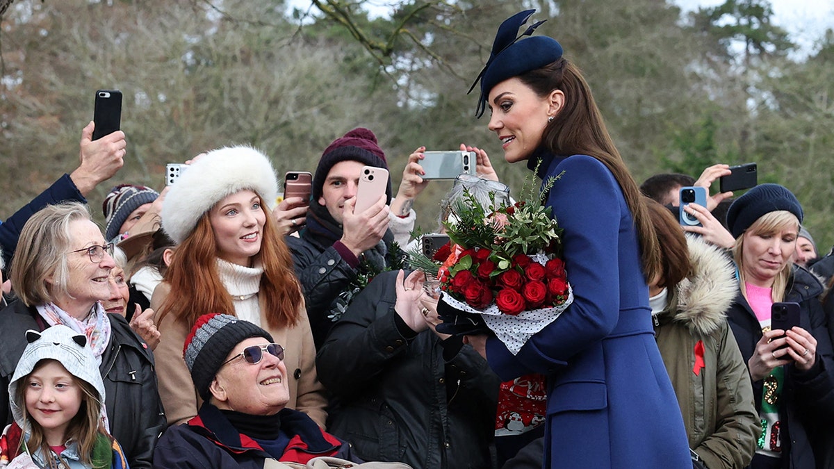 Kate Middleton accepts flowers during an appearance