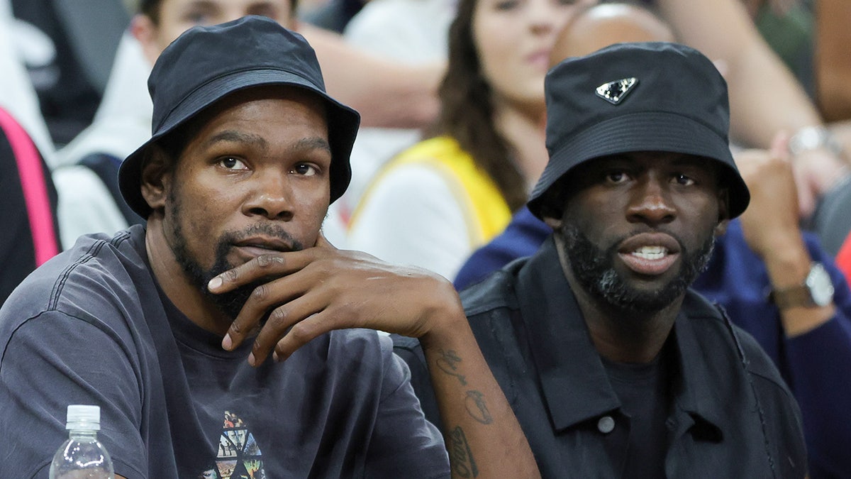 Kevin Durant and Draymond Green sit next to each other