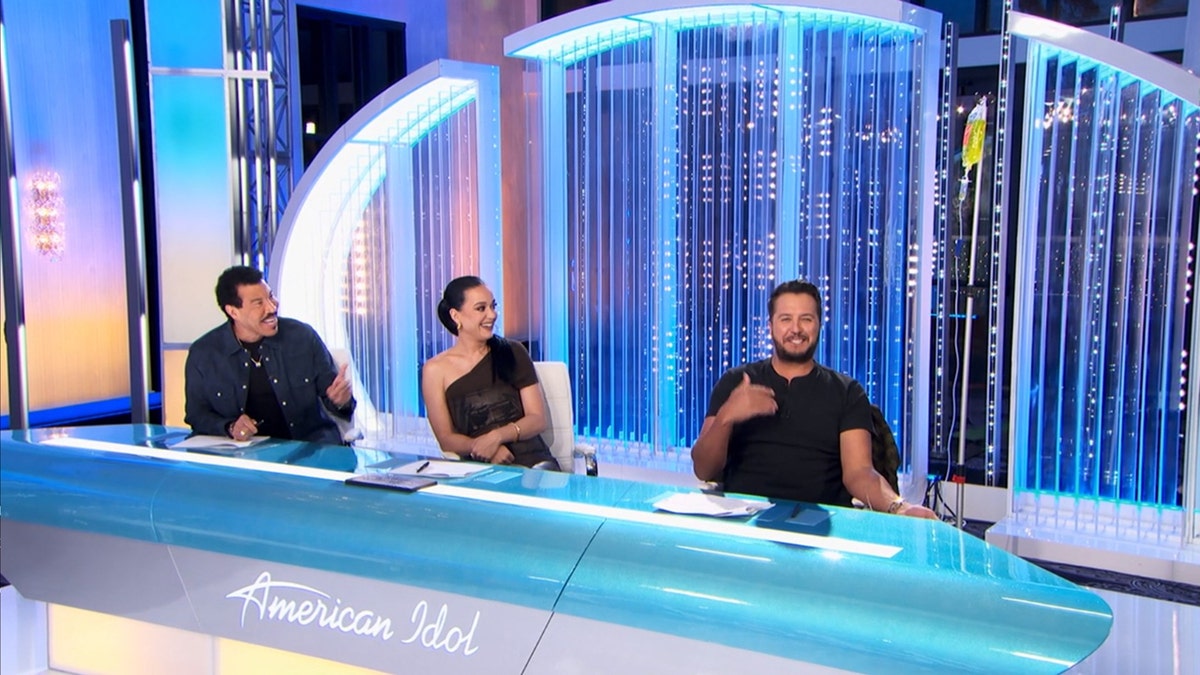 Lionel Richie, Katy Perry, and Luke Bryan look at Bryan's IV bag on the American Idol set