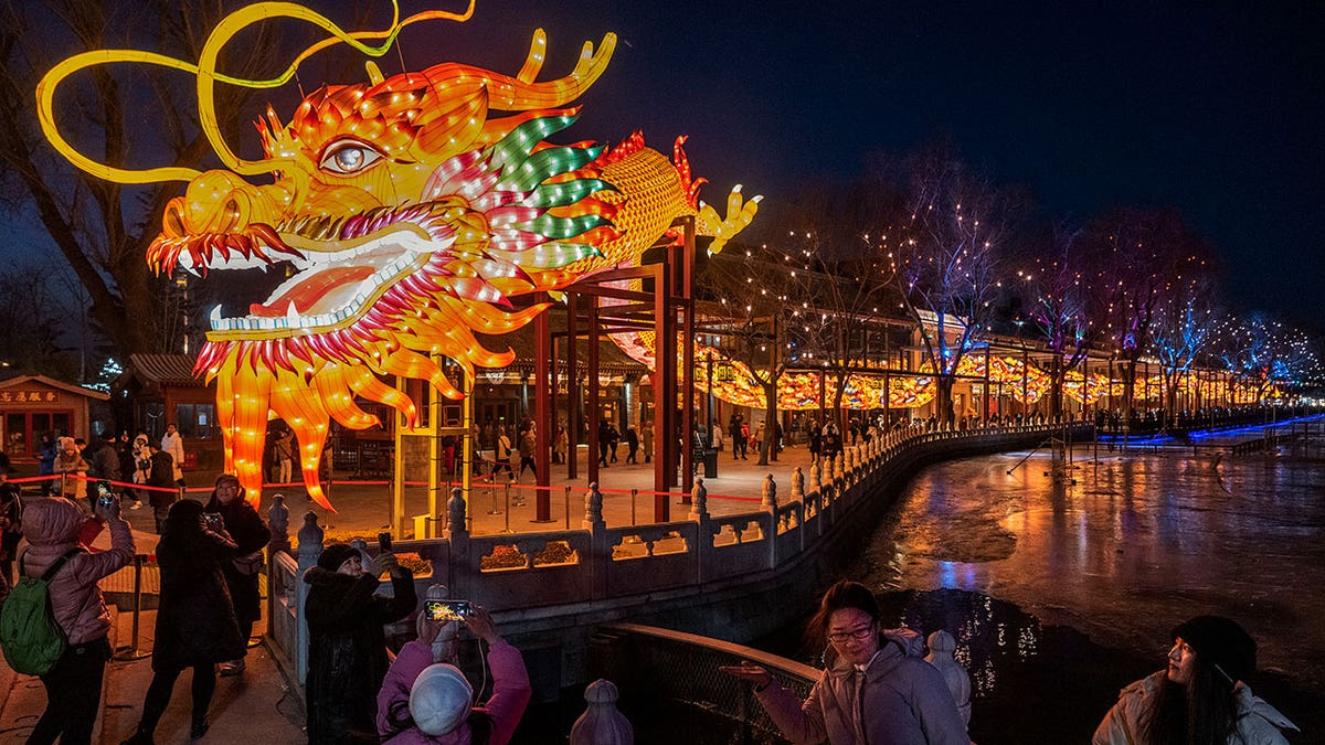 People gather around a large dragon figure